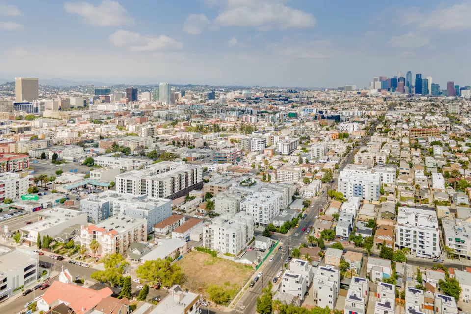 Aerial view of Koreatown neighborhood in Los Angeles with downtown skyline in background.